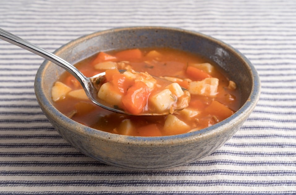 Bowl of Manhattan style clam chowder with spoonful