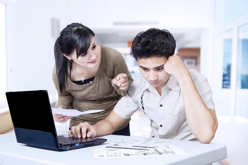 couple paying bills online at home