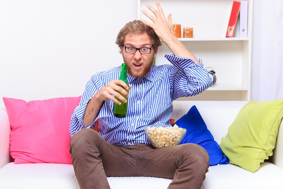 man yelling at his tv with popcorn and a beer man yelling at his tv with popcorn and a beer