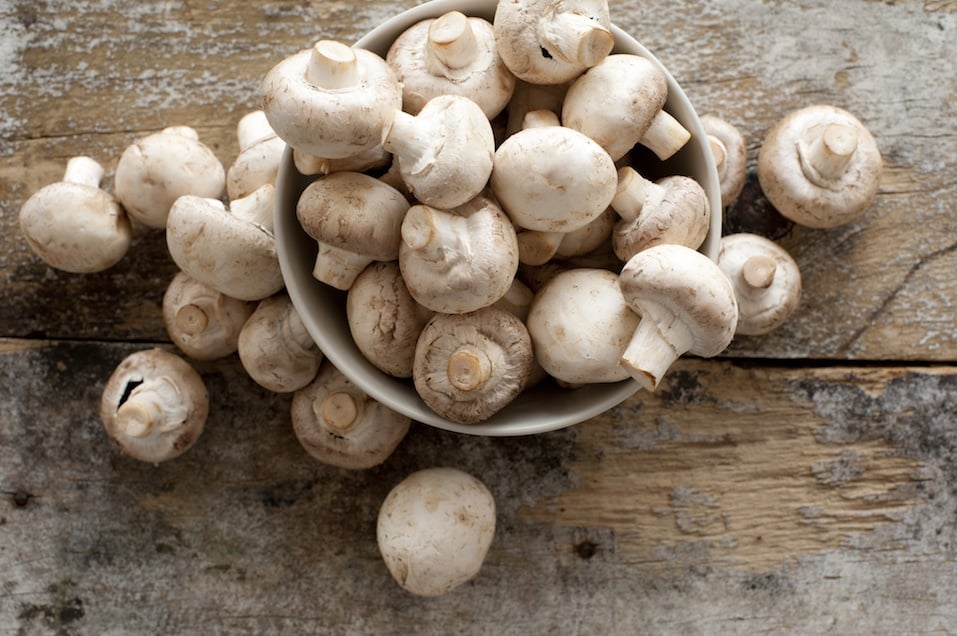 Agaricus, in a bowl on a rustic wooden counter ready to be cleaned and washed for dinner,