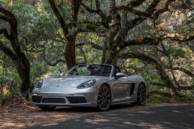 A silver Porsche 718 Boxster S with the top down