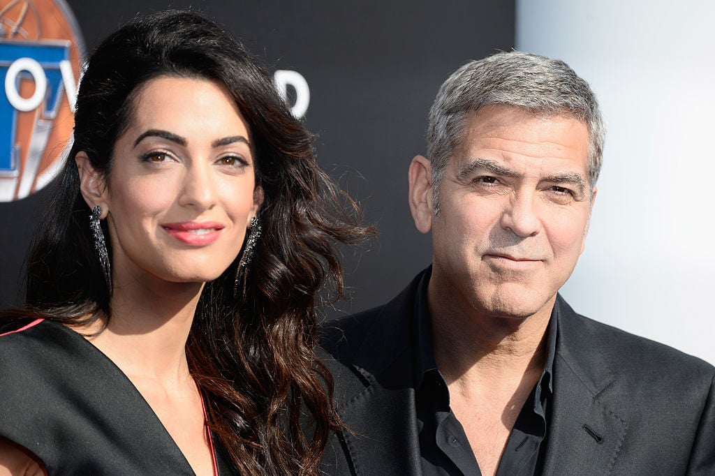 George and Amal Clooney smiling for the camera together on the red carpet George and Amal Clooney smiling for the camera together on the red carpet