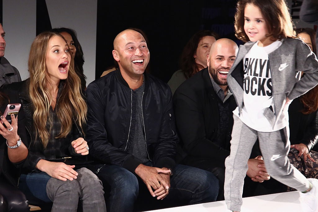 Derek Jeter and Hannah Davis smiling and laughing, while a child walks the runway at a fashion show. Derek Jeter and Hannah Davis smiling and laughing, while a child walks the runway at a fashion show.