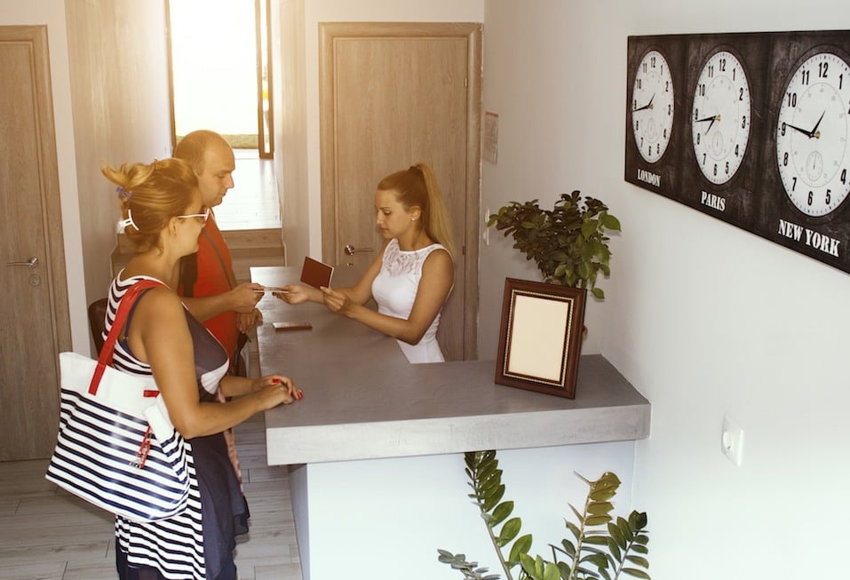 Hotel receptionist checking couple in