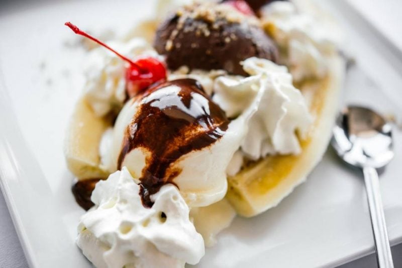 Banana split ice cream served on white plate