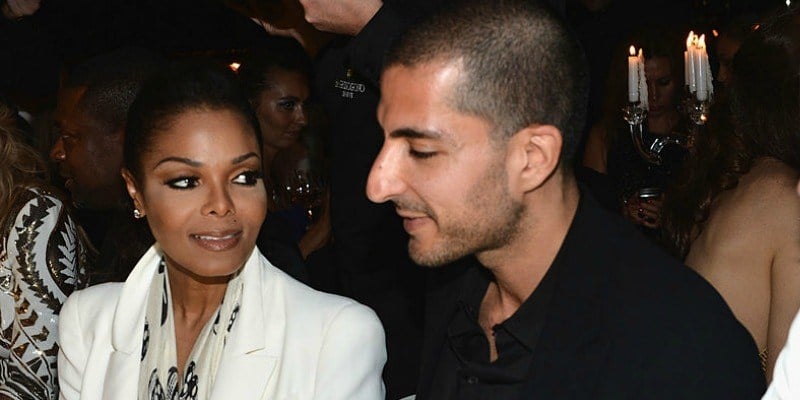 Janet Jackson is sitting next to Wissam Al Mana and is looking at him.