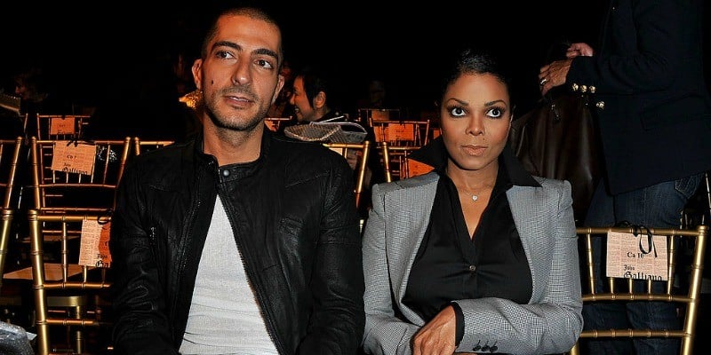 Wissam Al Mana and Janet Jackson look serious as they sit front row at a fashion show.