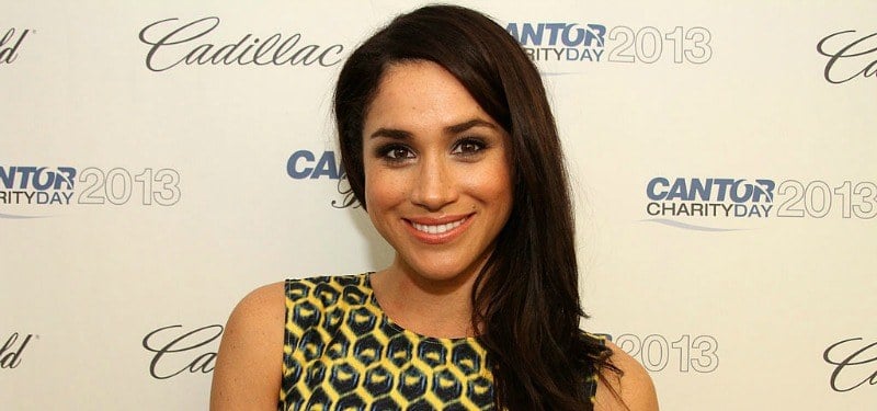Meghan Markle is smiling in a black and yellow dress on the red carpet. Meghan Markle is smiling in a black and yellow dress on the red carpet.
