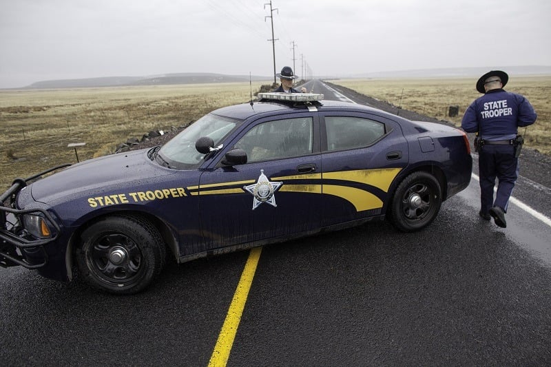 Oregon State Police officers monitor a closed area at a road checkpoint