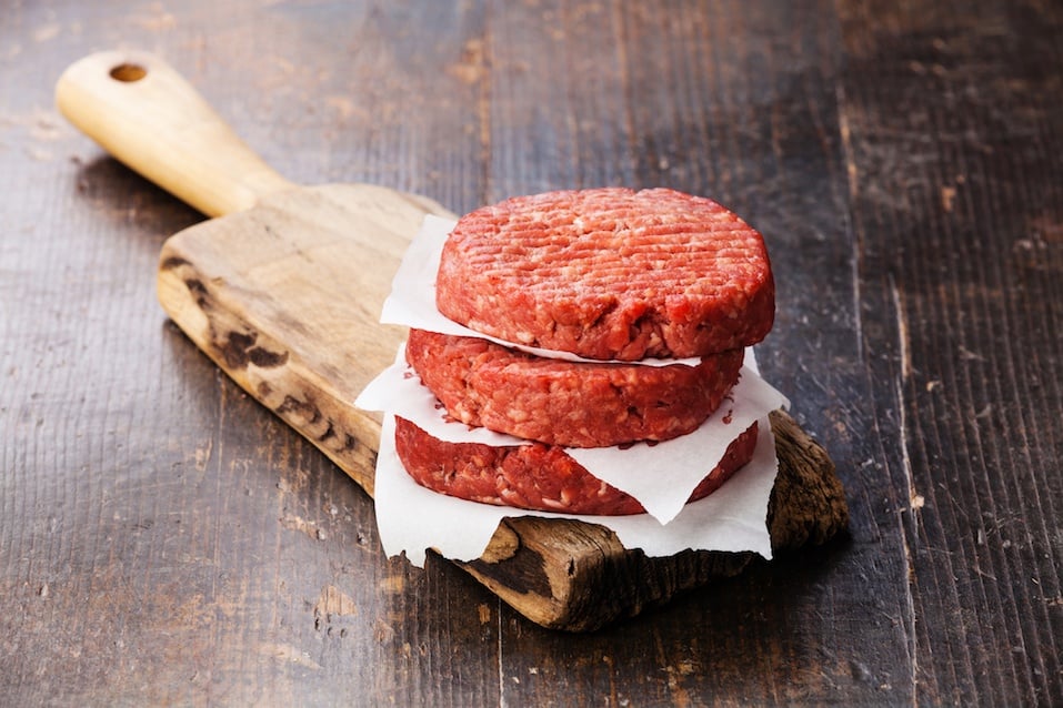 Raw Ground beef meat Burger steak cutlets on cutting board on dark wooden background