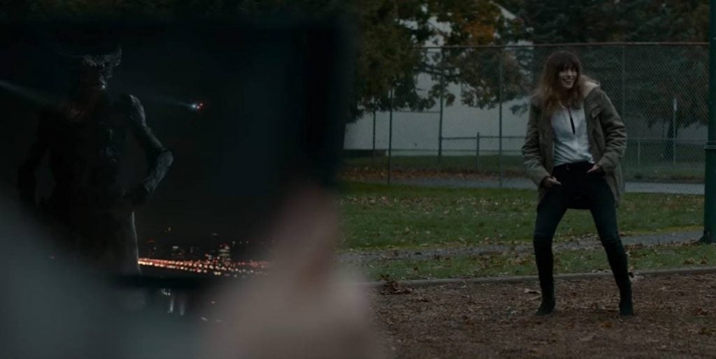 Anne Hathaway dancing on a playground, with a monster on an iPad in the foreground