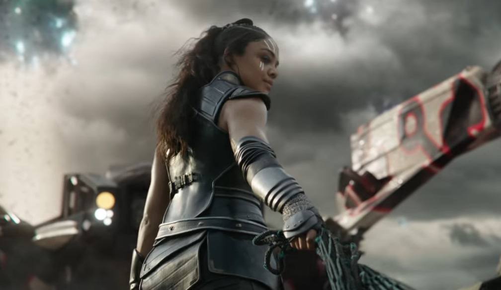 Tessa Thompson wearing armor, with her right hand out