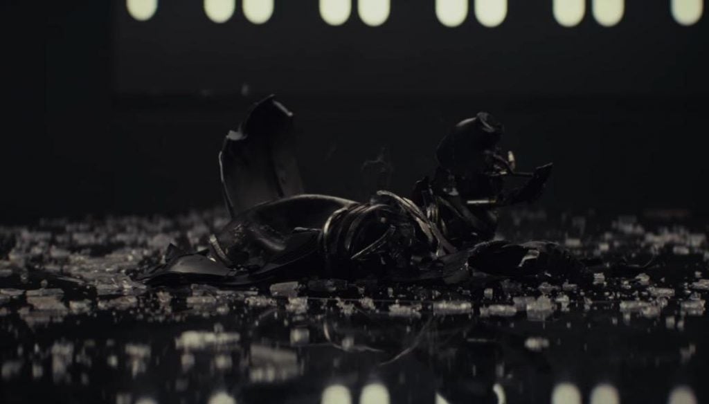A mask smashed to pieces among shattered glass