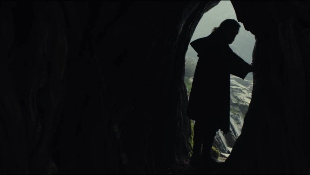 Luke looking back into a cave, silhouetted