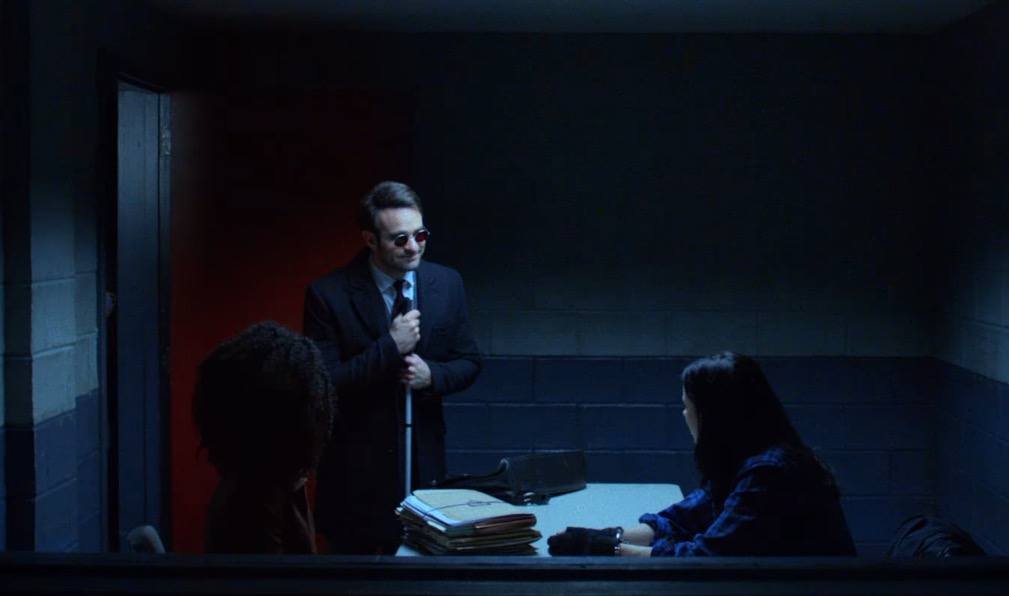 Matt Murdock smiling in an interrogation room with Jessica Jones
