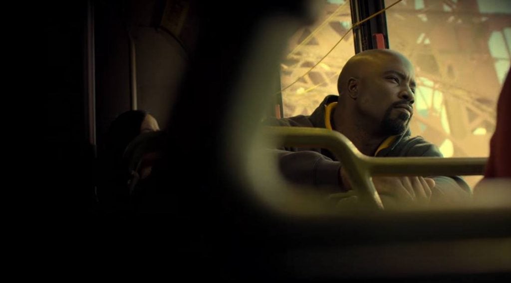 Luke Cage sitting on a bus, looking out a window
