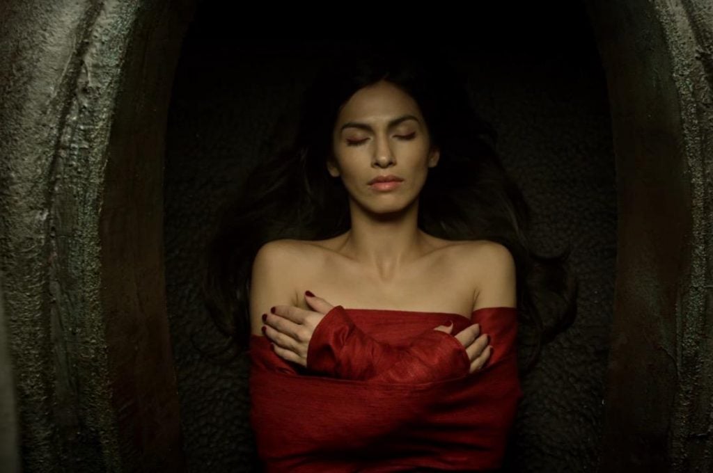 Elektra dead, prone, and with her arms crossed, wearing all red