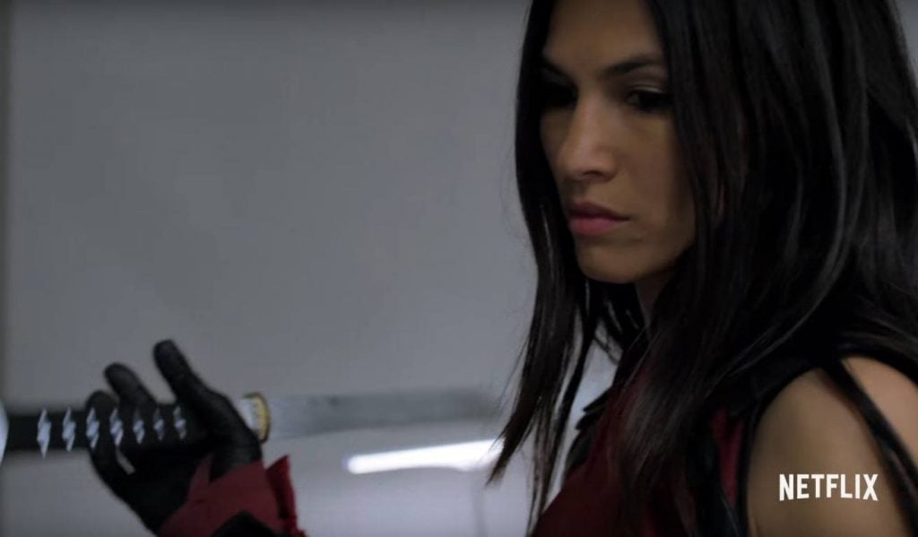 Elektra holding a katana, looking down, and preparing to fight