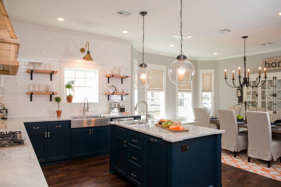 Several light fixtures highlight the wood and tile elements of this craftsman style kitchen as seen on Fixer Upper.