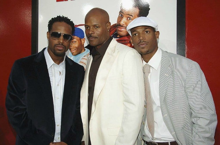 Actors and brothers Shawn Wayans, Keenen Ivory Wayans and Marlon Wayans in front of movie poster