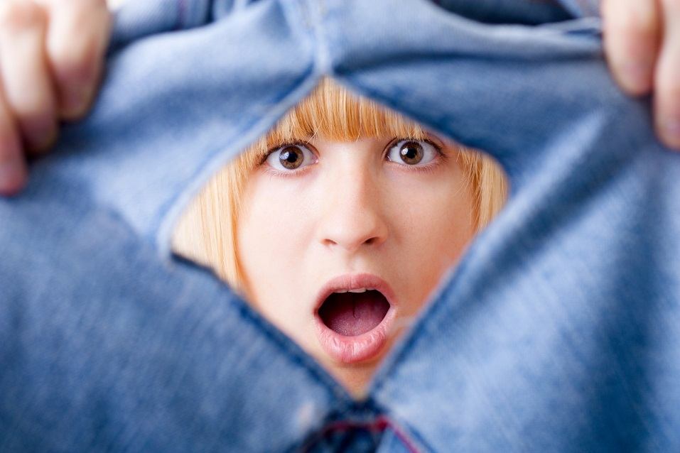 Woman looking into torn jeans