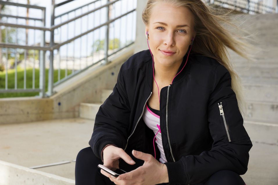 Smiling blonde woman sits outdoor