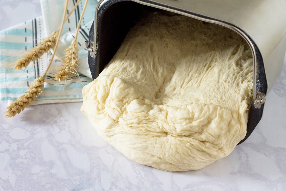 Fresh dough and ears on a stone gray background