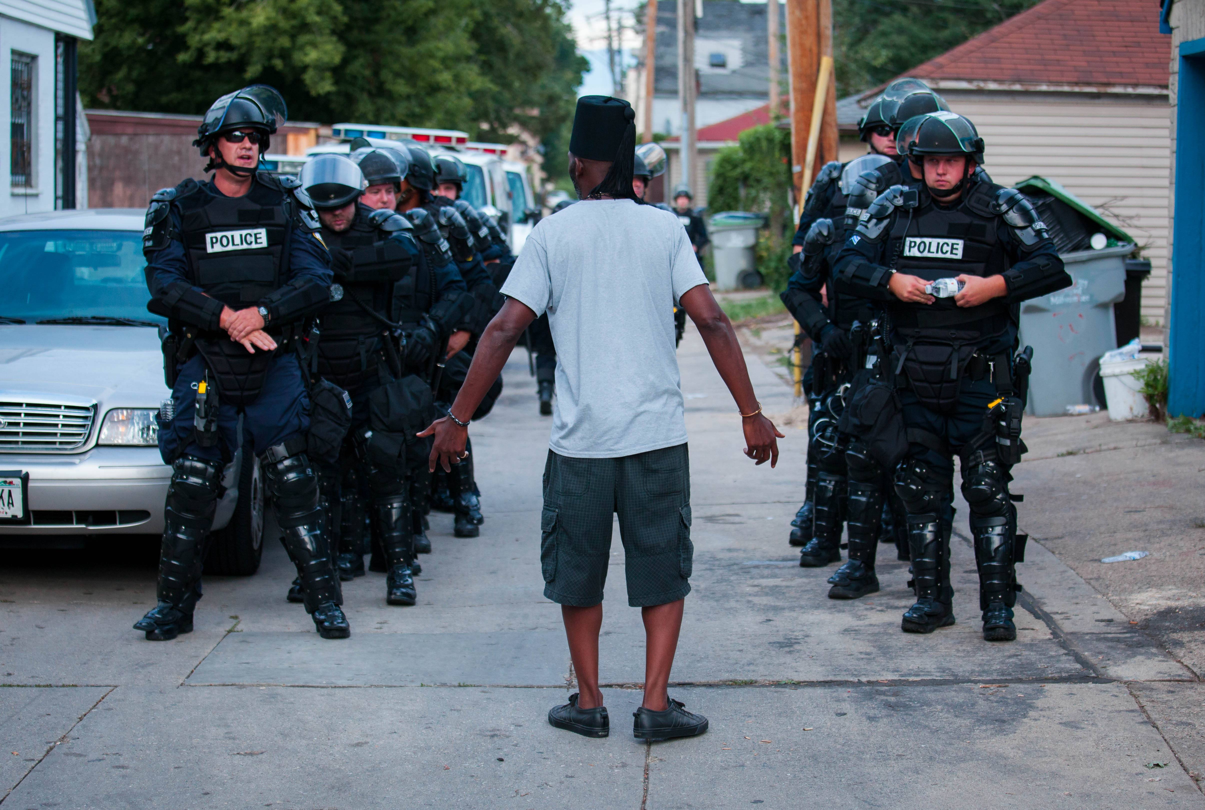 A man talks to police in riot gear