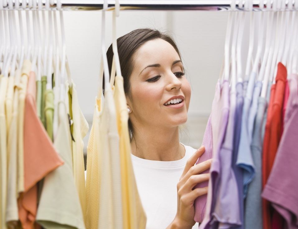 young female looking through a clothing closet