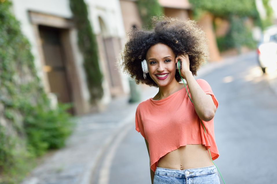 Young black woman with afro hairstyle smiling in urban park