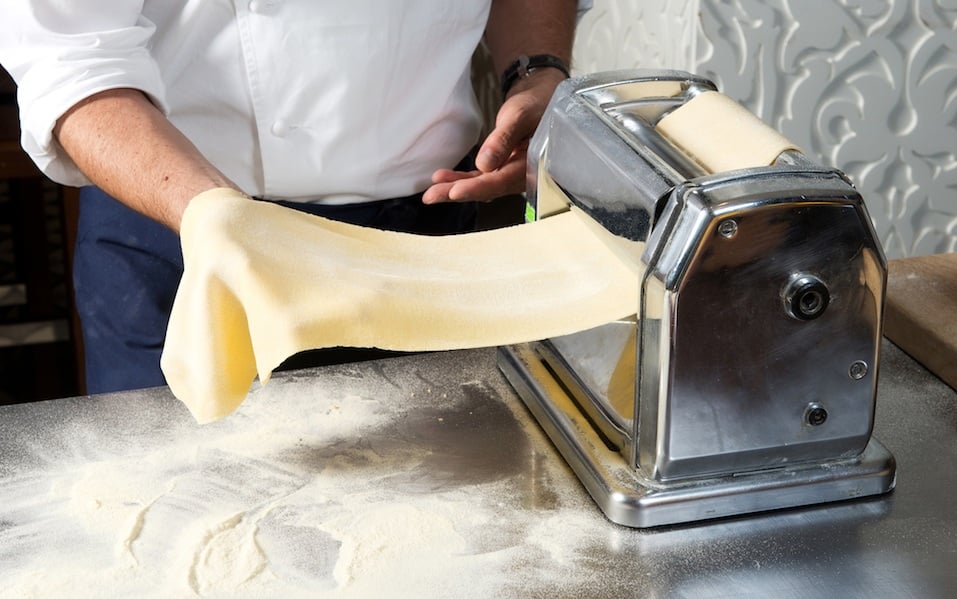 Young man chef prepares homemade pasta