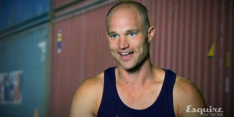 Brian Arnold is talking and wearing a blue tank top on Team Ninja Warrior.