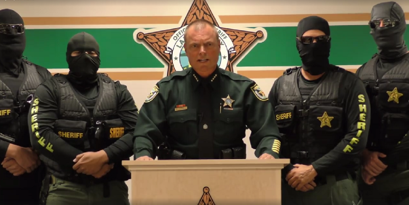 Police officers speak at a podium