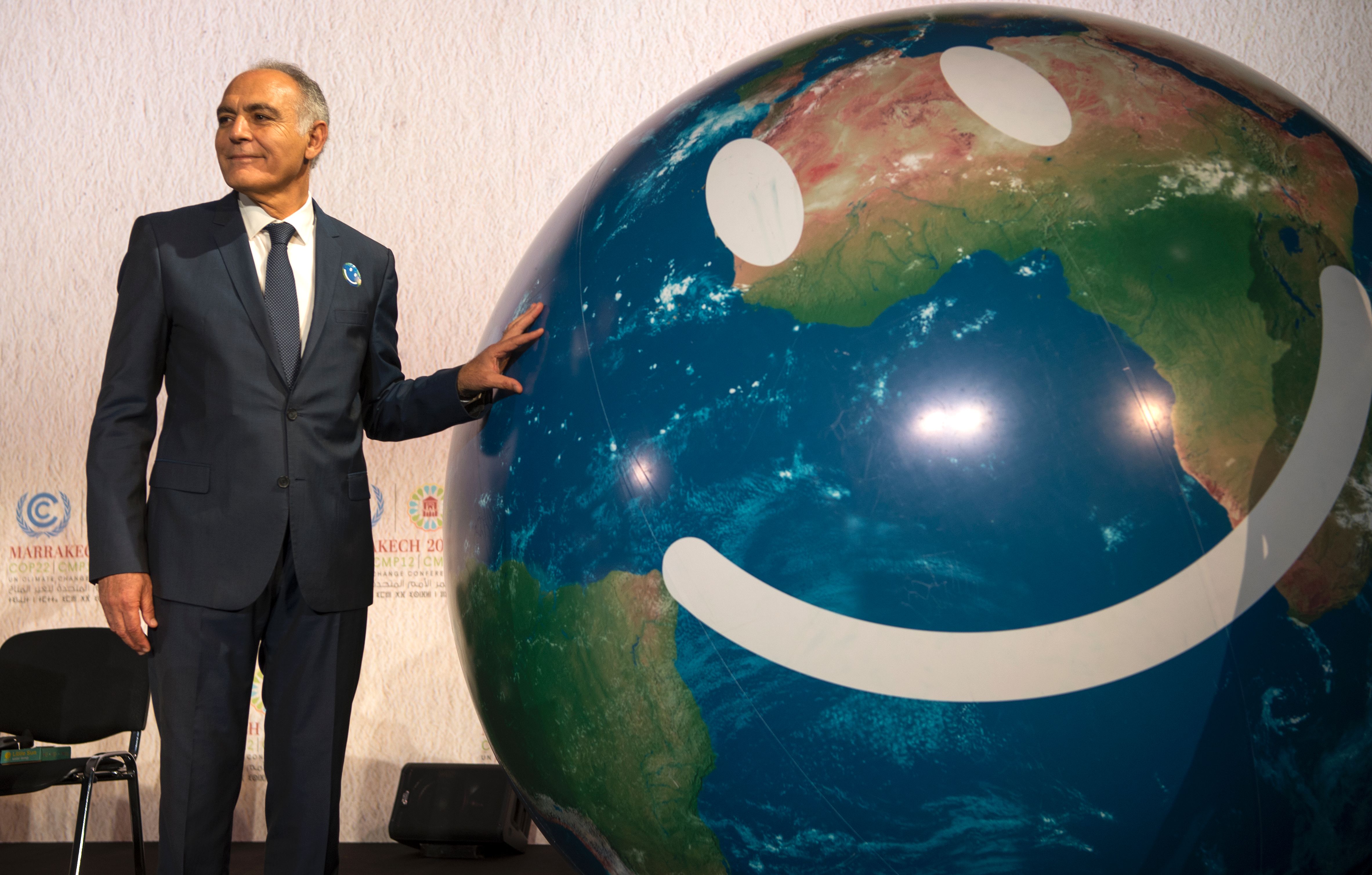 COP22 president Salaheddine Mezouar caresses a smiley Earth ball during a climate change summit