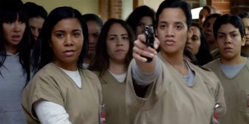 Daya holds up a gun next to other inmates on Orange is the New Black.