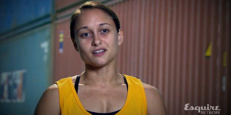 Erica Cook is talking to the camera and wearing a yellow tank top on Team Ninja Warrior.