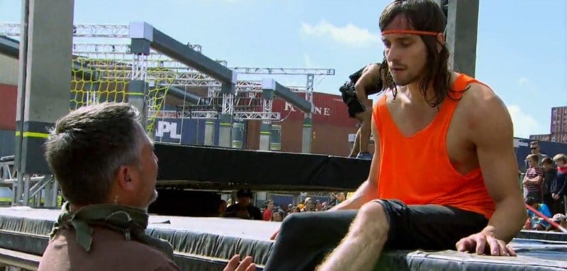 Jake Murray is sitting on the side of the course as a man tends to his leg.