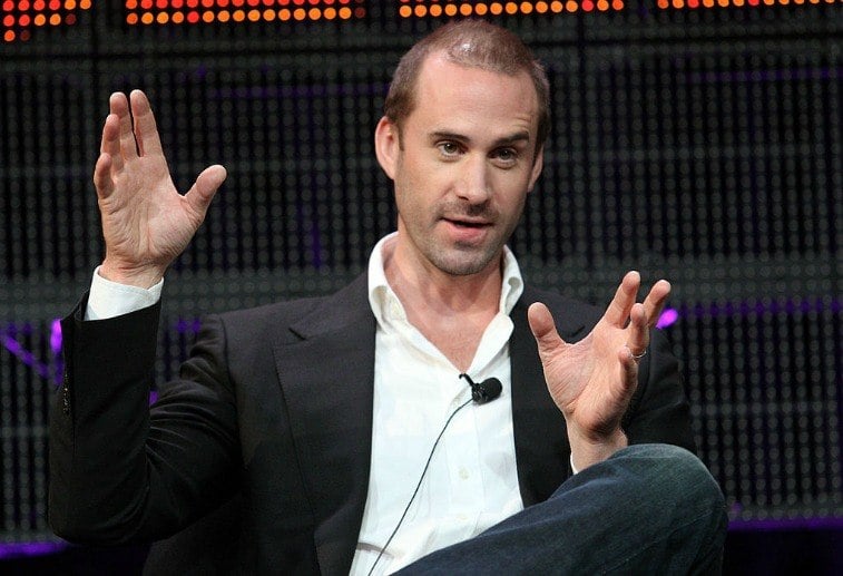 Man sitting in a chair gesticulating while he talks
