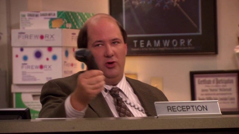 Kevin Malone of The Office, feeling confused about his job description, acts as receptionist.