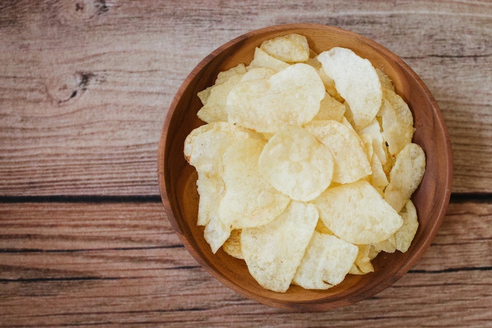 potato chips on light wooden background