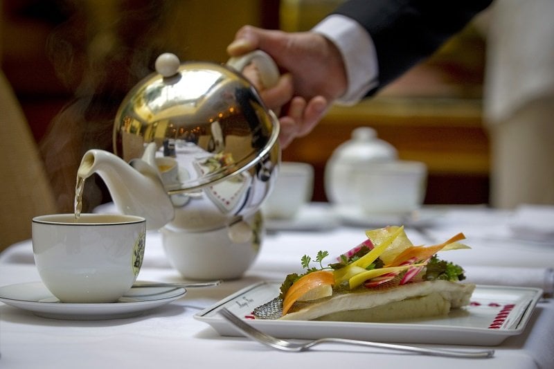 pouring tea at a fancy restaurant table