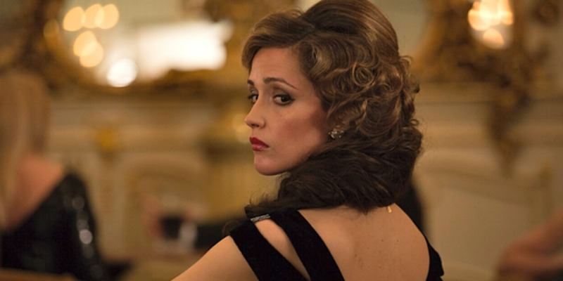 Rose Byrne looks over her shoulder in a black dress in Spy.