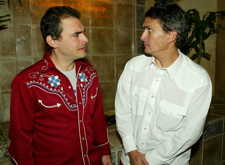 'Yes Men' Mike Bonano and Andy Bichlbaum look at one another outside next to a tile wall
