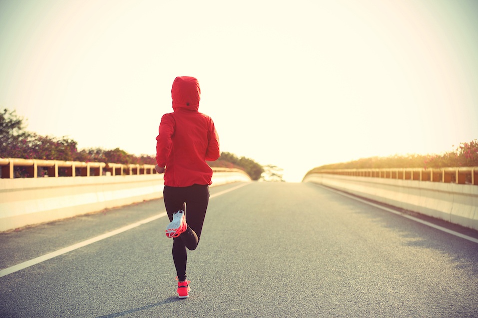 Woman runner running on city road