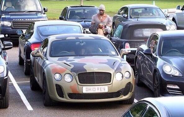 Picture of Italian soccer star Mario Balotelli approaching his camouflage Bentley in a parking lot