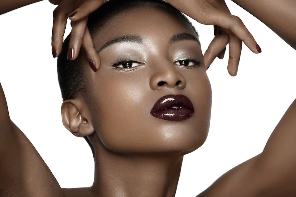 model wearing plum lipstick and dark nail polish