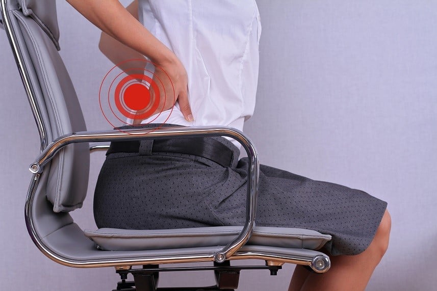 woman with back pain sitting in an office chair woman with back pain sitting in an office chair