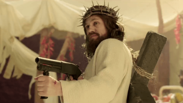 Christoph Waltz holds a machine gun dressed as Jesus.