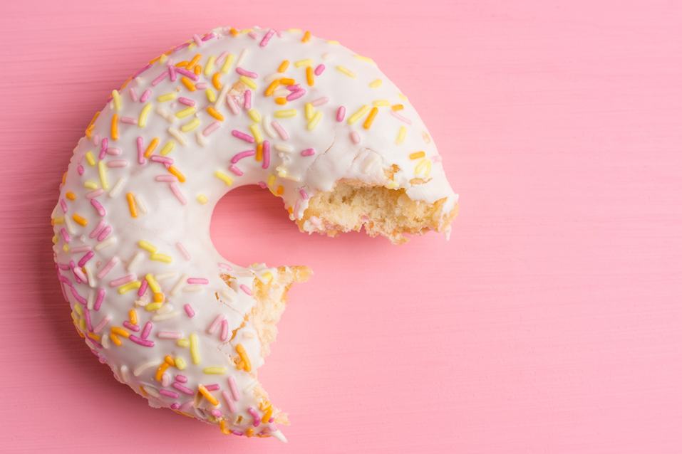 Donut with sprinkles on the pink background Donut with sprinkles on the pink background