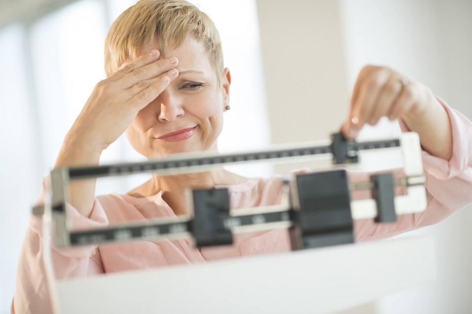 woman adjusting weight scale woman adjusting weight scale